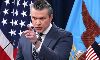 Pete Hegseth points at someone or something with his index finger