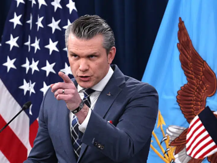Pete Hegseth points at someone or something with his index finger