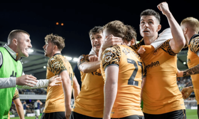 Hull City AFC players hug one another in celebration on the pitch