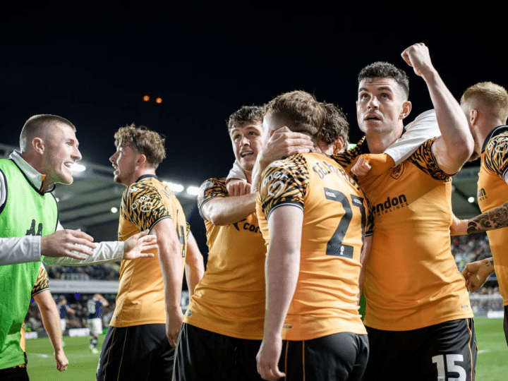 Hull City AFC players hug one another in celebration on the pitch
