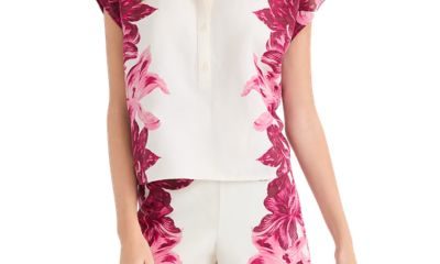 A woman wearing a white-and-pink floral top and matching shorts