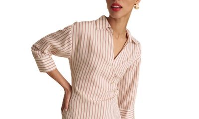 A woman wearing brown pants with a ivory-and-orange striped blouse