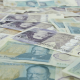 British bank notes laid flat. Sunday Times Rich List features 350 wealthy families or individuals resident in the UK