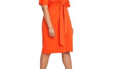 A woman wearing a bright orange dress with croc-print open-toed heals