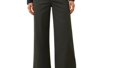 A woman (lower half of body) wearing dark brown pants and light brown sandals