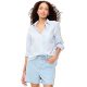 A woman wearing a light blue button-front shirt and light blue denim shorts