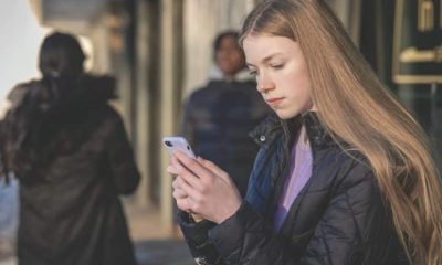 A girl looks at a mobile phone Online misogyny Barnardo's