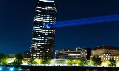 Projection onto Millbank Tower reading Resist Reform