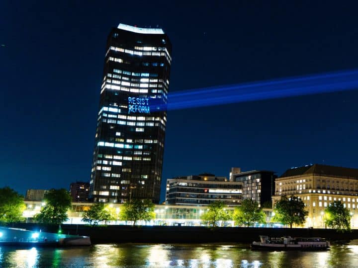Projection onto Millbank Tower reading Resist Reform