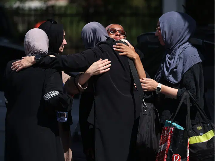 Female Muslim mosque members embrace in the parking lot of the Islamic Center of San Diego (ICSD) on May 19, 2026 in San Diego, California.