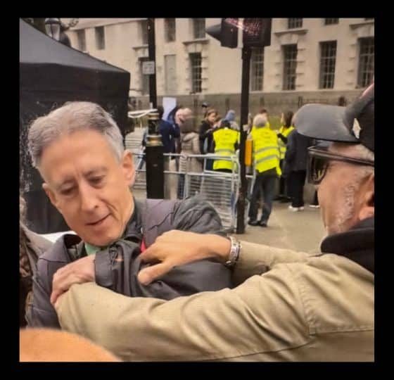 a man grabs Peter Tatchell at the Rally Against Antisemitism