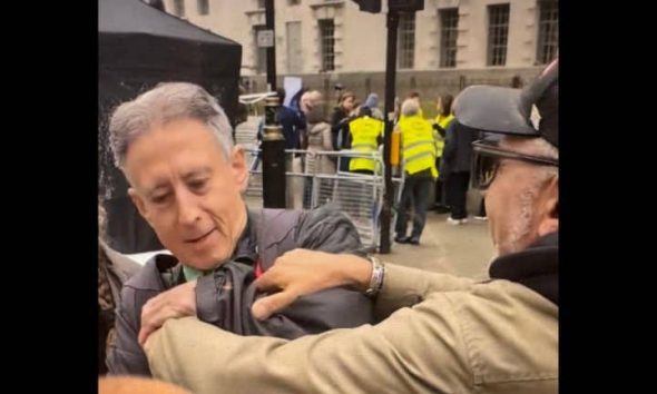 a man grabs Peter Tatchell at the Rally Against Antisemitism