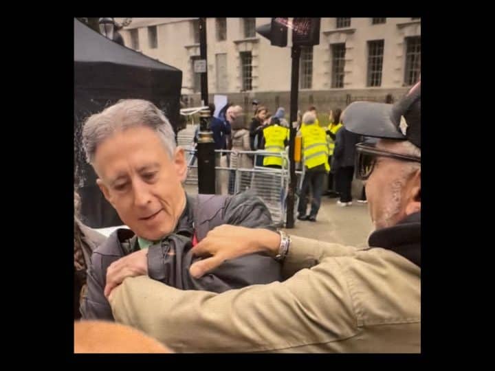 a man grabs Peter Tatchell at the Rally Against Antisemitism