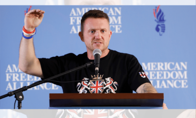 Tommy Robinson holding his hand up