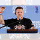 Tommy Robinson holding his hand up