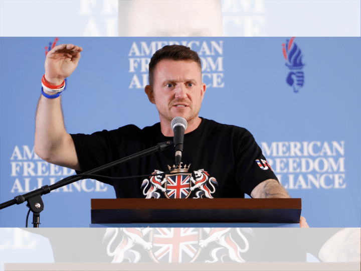 Tommy Robinson holding his hand up