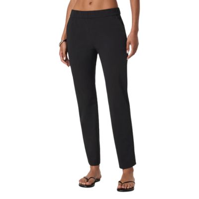 A woman (lower half of body shown) wearing black pants and black thong sandals