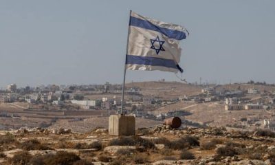 A tattered Israel flag flies near a West Bank settlement