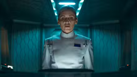 Dedra Meero (Denise Gough) standing in front of a communications screen in a small room in Andor Season 2