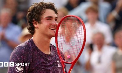 Joao Fonseca holds his racquet to his face in celebration