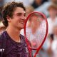 Joao Fonseca holds his racquet to his face in celebration