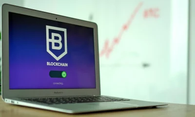 Laptop displaying a blockchain login screen with connecting status.