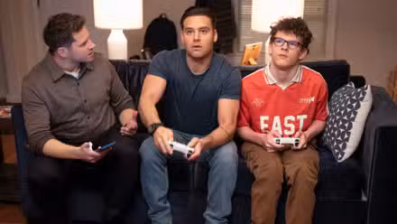 Buck, Eddie, and Christopher sitting on the couch playing video games in 9-1-1 Season 9 Episode 12