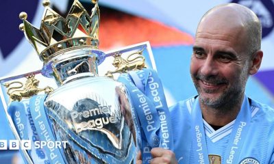 Manchester City manager Pep Guardiola holding the Premier League trophy