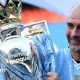 Manchester City manager Pep Guardiola holding the Premier League trophy