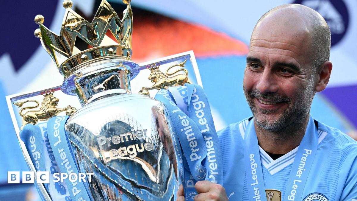 Manchester City manager Pep Guardiola holding the Premier League trophy