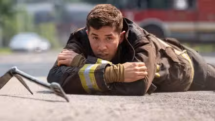 A firefighter lying on the ground in Chicago Fire.