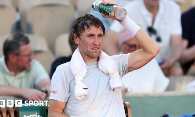 Casper Ruud pours water over his head during a change of ends