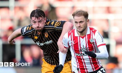 Hull defender Charlie Hughes has his left hand on the right shoulder of Southampton player Leo Scienza, who is wearing gloves