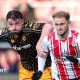 Hull defender Charlie Hughes has his left hand on the right shoulder of Southampton player Leo Scienza, who is wearing gloves