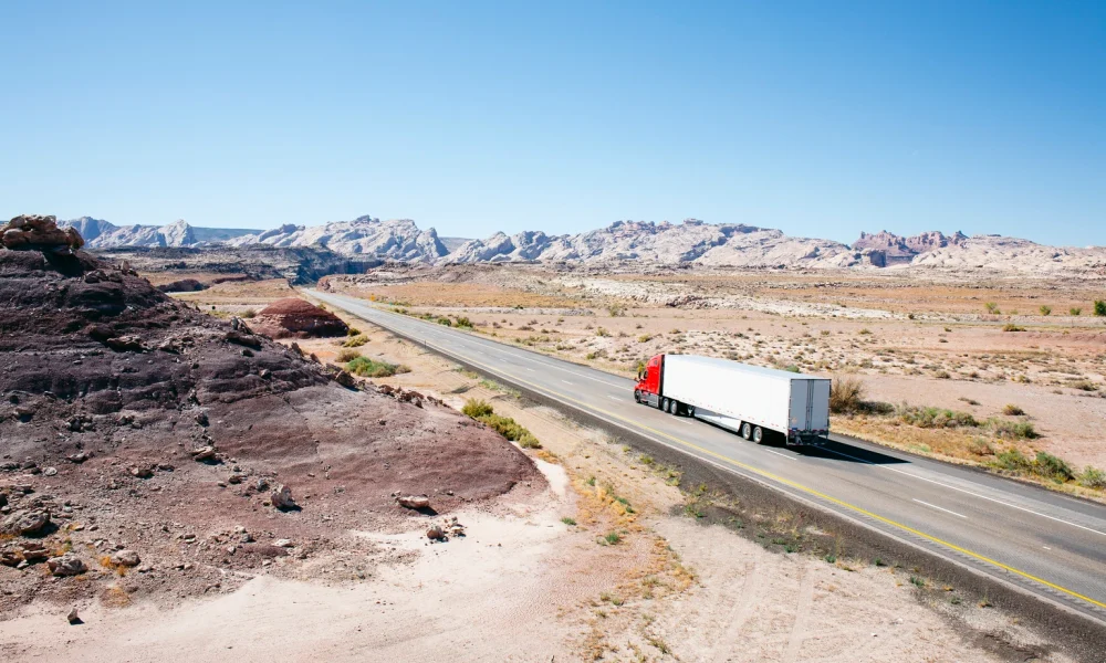 Truck on a desert road leading into the distance