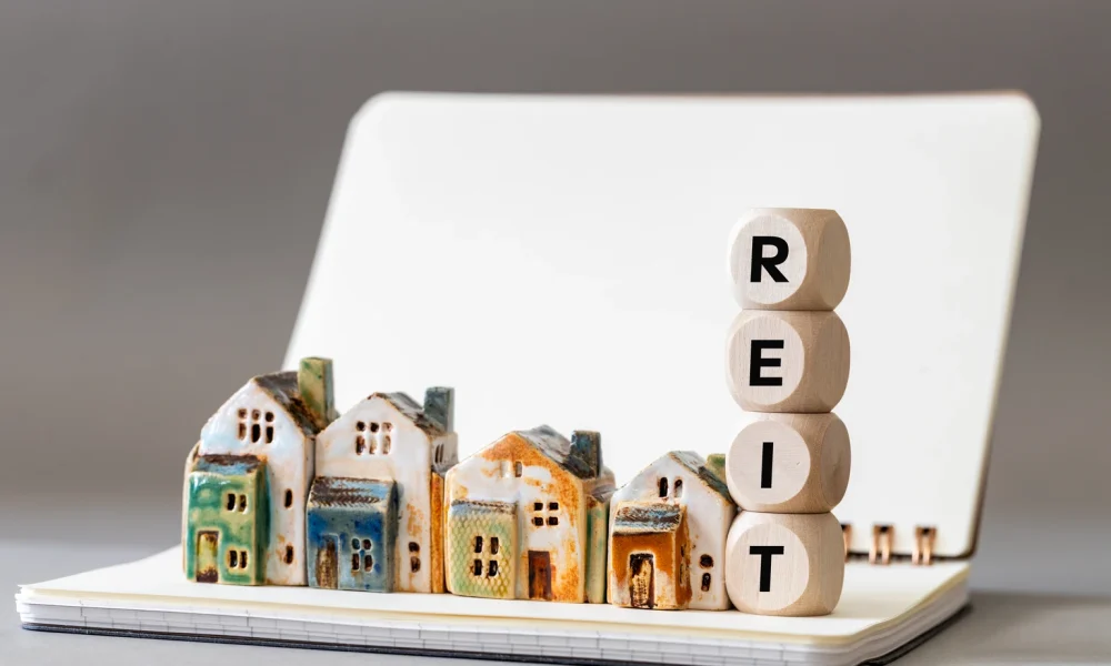 REIT symbol. Real Estate Investment Trust, Real Estate Investment Trusts with miniature houses Investment concept. copy space, business background