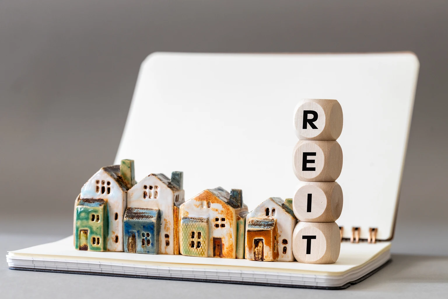 REIT symbol. Real Estate Investment Trust, Real Estate Investment Trusts with miniature houses Investment concept. copy space, business background