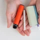 Woman holding regular, electronic cigarette and disposable vape on white background. Tobacco heating systems.