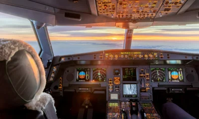 Cockpit of commercial jet illuminated at sunrise during flight