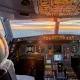 Cockpit of commercial jet illuminated at sunrise during flight