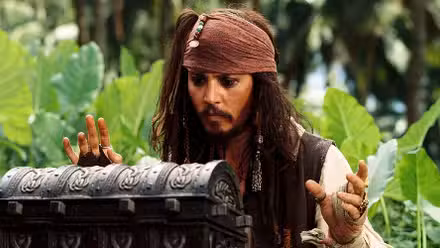 Johnny Depp as Jack Sparrow in Pirates of the Caribbean Dead Man's Chest looking at a treasure box