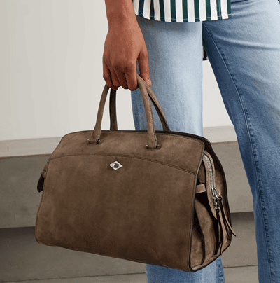 woman carries brownish suede tote