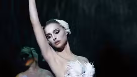 Natalie Portman as Nina Sayers performing ballet onstage in a white feathered costume in Black Swan.
