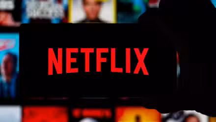 Image of someone holding a phone with the Netflix logo.