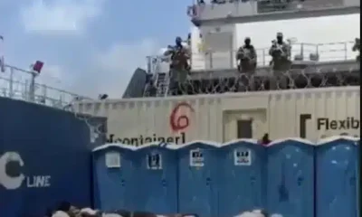 Bodies, likely of the Global Sumud Flotilla volunteers, crouch over in rows on what appears to be the deck of a ship