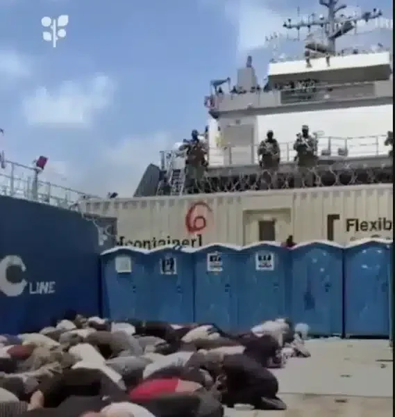 Bodies, likely of the Global Sumud Flotilla volunteers, crouch over in rows on what appears to be the deck of a ship