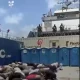 Bodies, likely of the Global Sumud Flotilla volunteers, crouch over in rows on what appears to be the deck of a ship