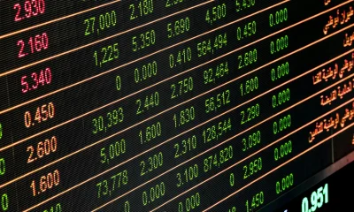 Close-up of a digital stock market display showing various stock prices and trading data.