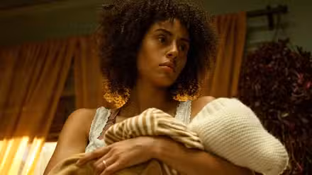 Clark Backo staring into space and holding a baby in The Changeling