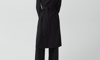 woman wears black belted trench coat